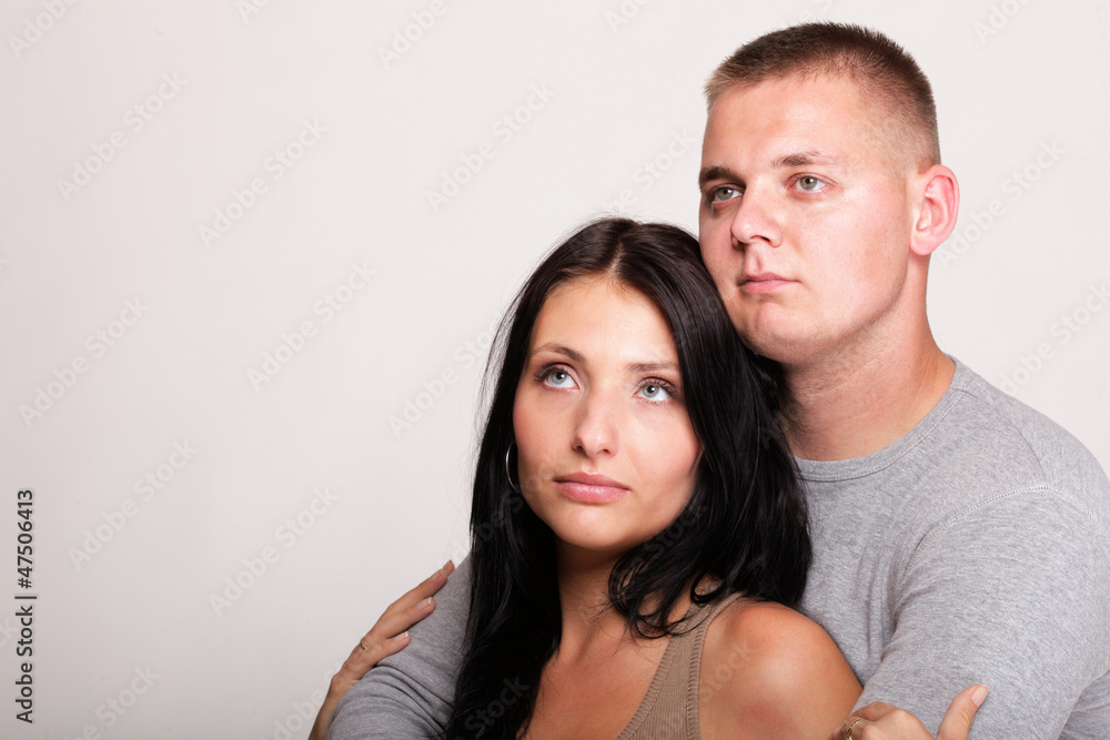 Beautiful pensive man woman stand near gray wal Beautiful pensive man woman stand near gray wal