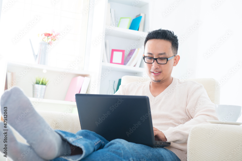 Asian male using internet at home Asian male using internet at home