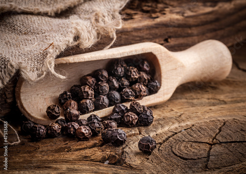 Black pepper on the rustic old wooden table
