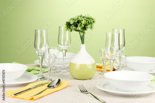 Table setting in green and yellow tones on color  background © Africa Studio