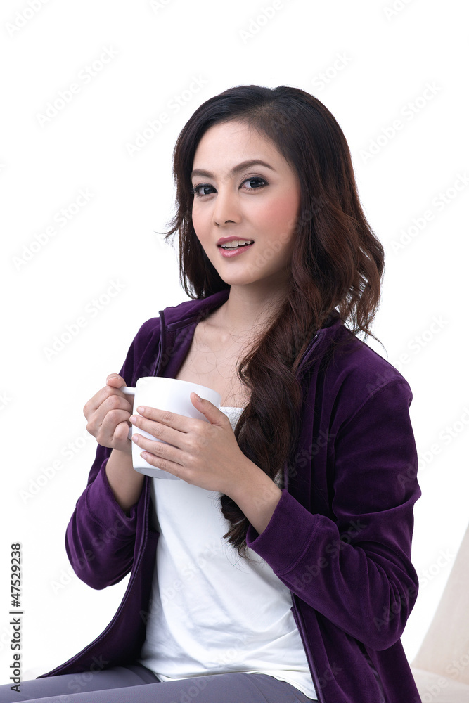 A beautiful young woman sitting and holding a cup of coffee A beautiful young woman sitting and holding a cup of coffee