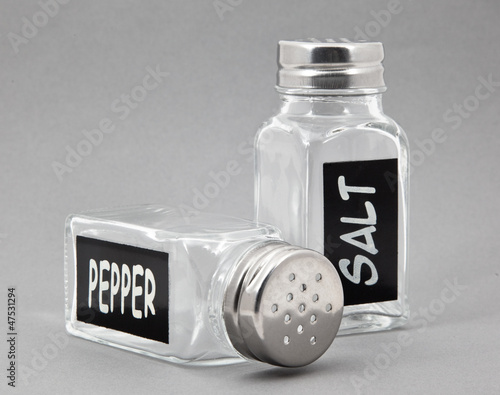 Empty glass saltshaker and pepperbox