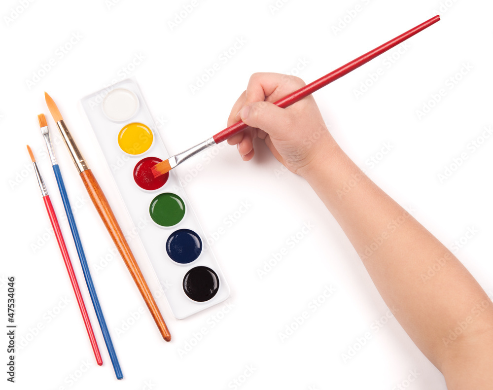 Fototapeta premium child's hand paints with watercolors and brush
