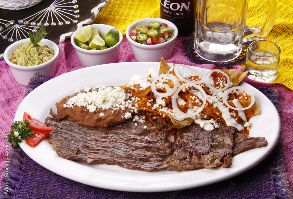 Chilaquiles en salsa roja con bistec. Comida mexicana