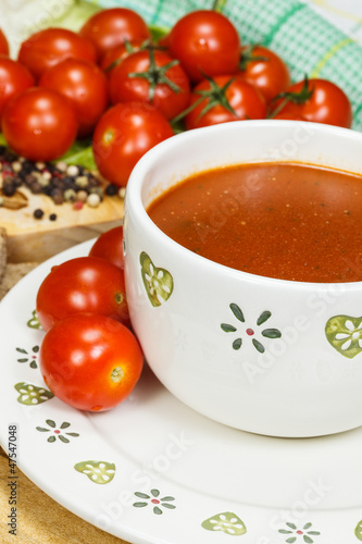 Tomato soup with tomatoes in background