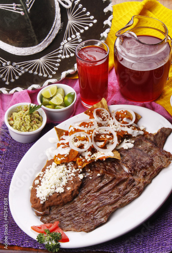 Chilaquiles en salsa roja con bistec. Comida mexicana