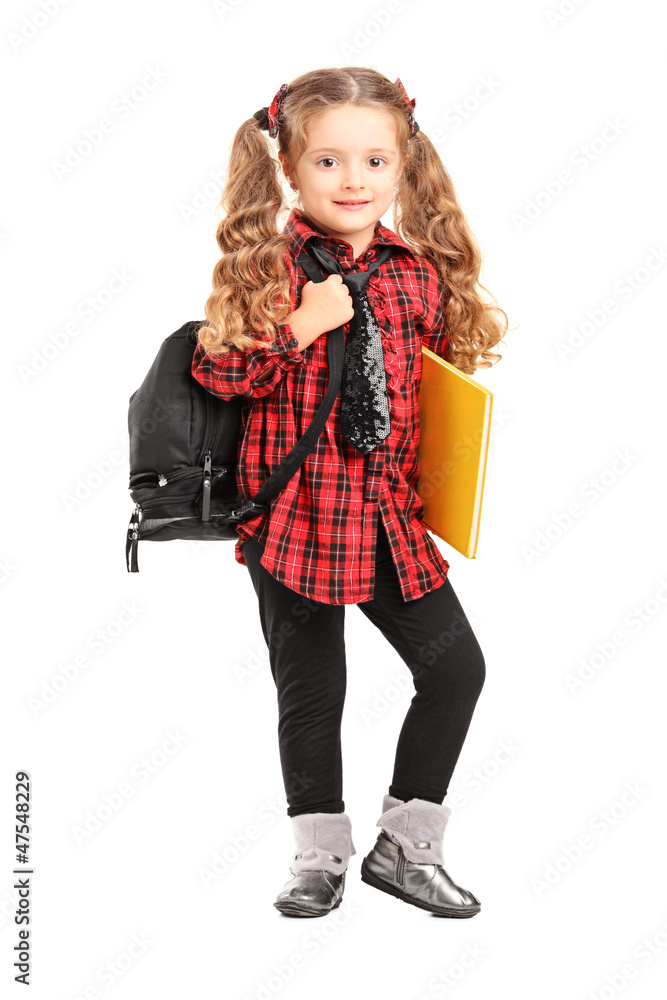 Llittle girl standing with backpack and book