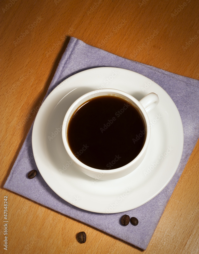 White coffee cup and saucer on a napkin White coffee cup and saucer on a napkin