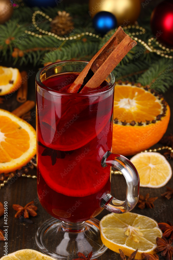 Fragrant mulled wine in glass with spices and oranges around Fragrant mulled wine in glass with spices and oranges around