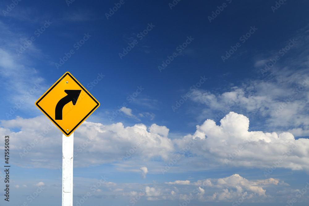 Direction sign- right turn warning on blue sky background Direction sign- right turn warning on blue sky background