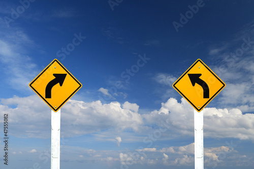 Left and right turn warning sing on blue sky background