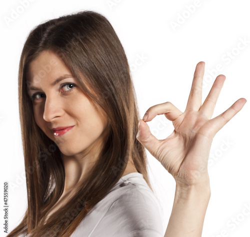 Portrait of cheerful young woman gesturing okay