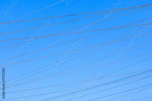 power lines in rural landscape with blue sky