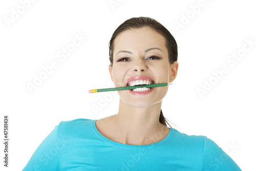 Thoughtful woman biting pencil
