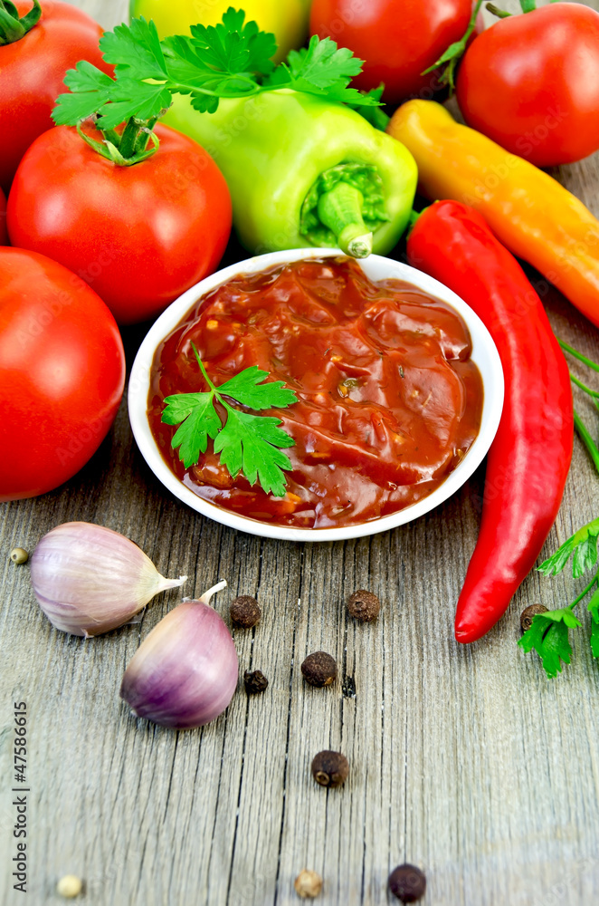 Ketchup with vegetables and spices on an old board Ketchup with vegetables and spices on an old board