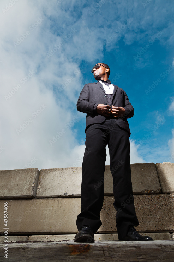 Cool black american man in dark suit wearing sunglasses. Cool black american man in dark suit wearing sunglasses.