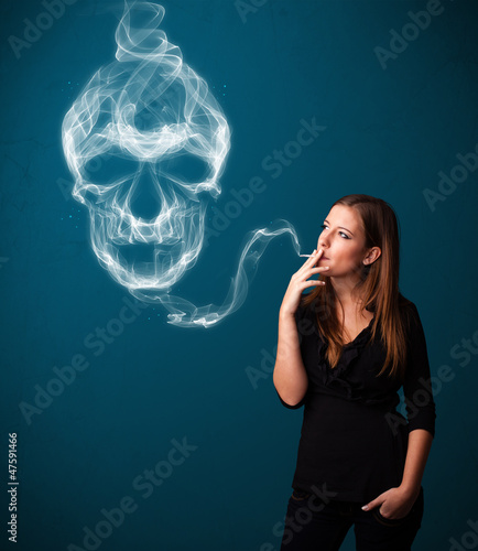 Fotografie Young woman smoking dangerous cigarette with toxic skull smoke
