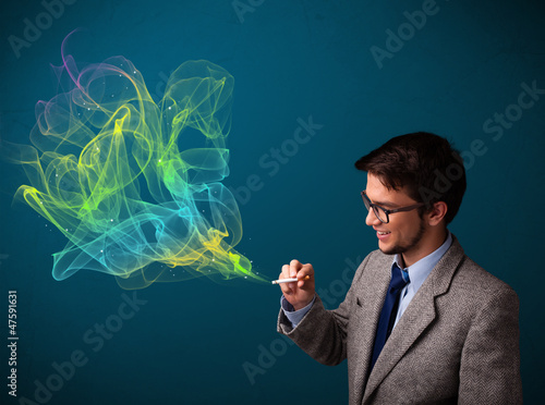 Handsome man smoking cigarette with colorful smoke