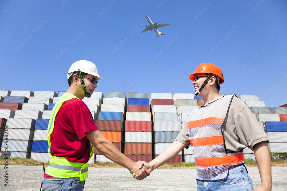 two happy workers handshaking before transportation containers two happy workers handshaking before transportation containers