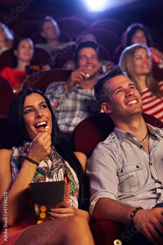 Young couple sitting in cinema smiling