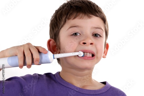 Boy brushing teeth with electric toothbrush
