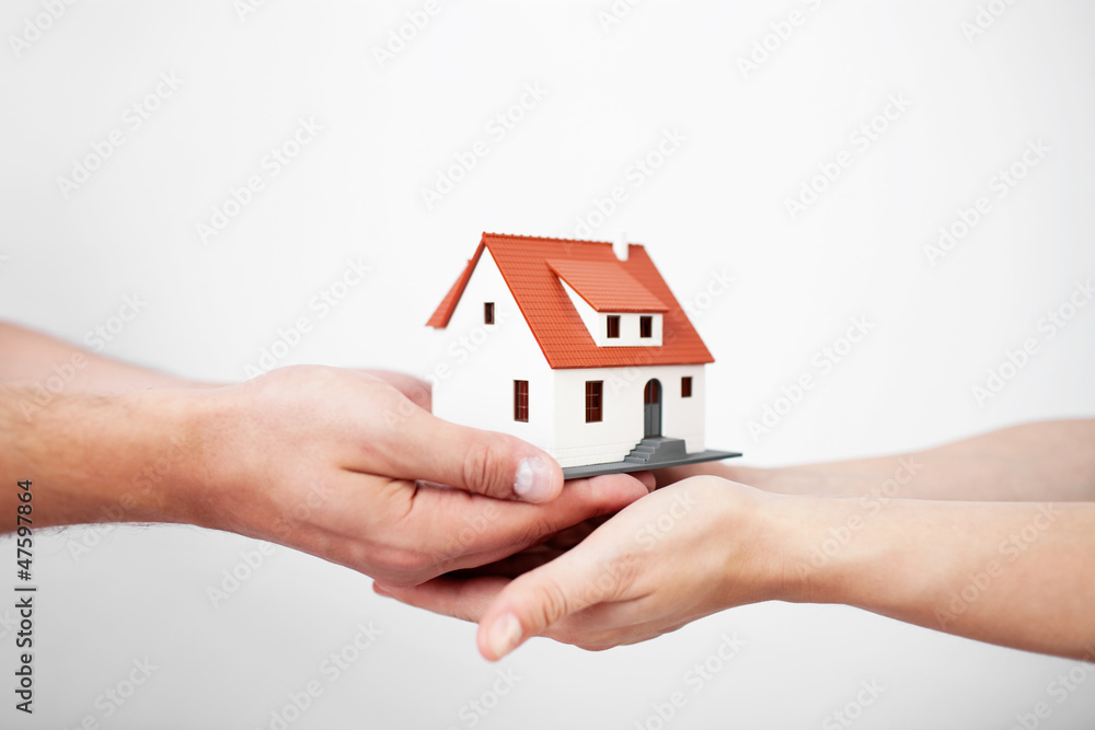 © baranq - Couple holding miniature house