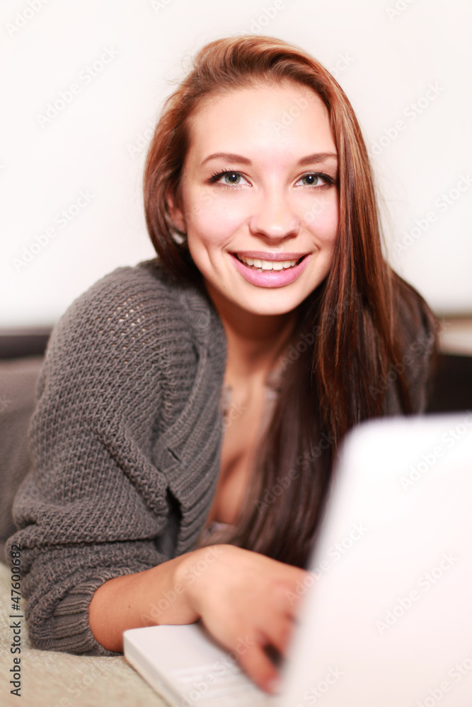 Dunkelhaarige Frau auf dem Sofa mit Laptop Dunkelhaarige Frau auf dem Sofa mit Laptop