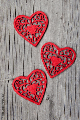 Three hearts on wooden background