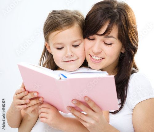 Mother is reading book with her daughter