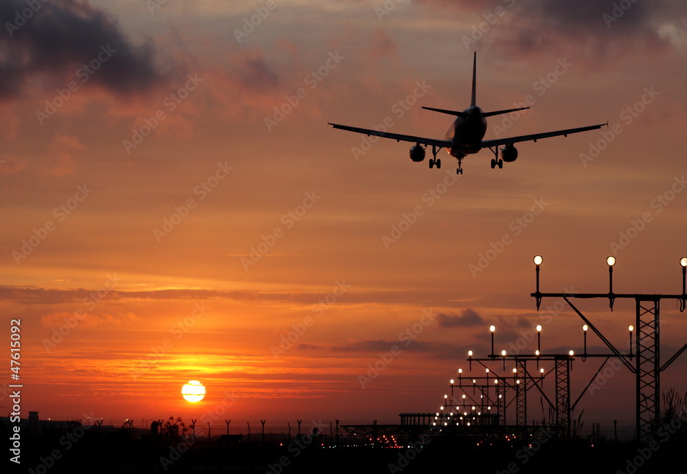Plane landing in a sunset Plane landing in a sunset