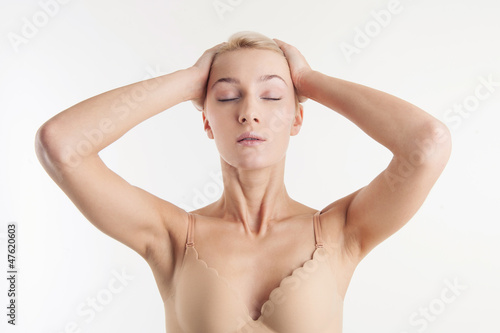 Beautiful woman portrait with closed eyes in beige bra 