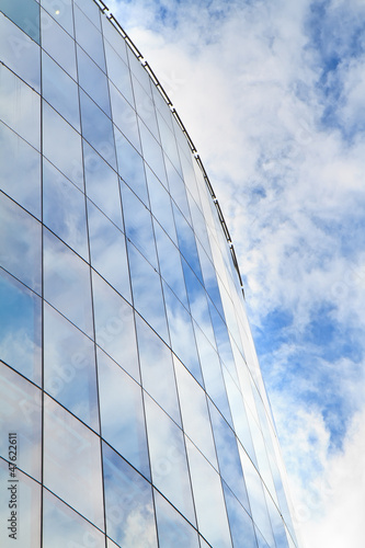 highrise glass building with sky and clouds reflection