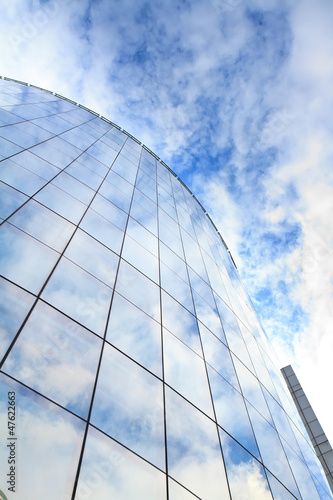 highrise glass building with sky and clouds reflection