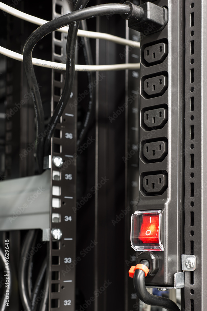 black power bar in server rack with red main switch button Stock Photo
