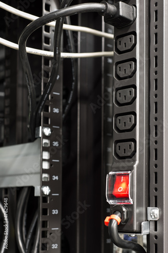 black power bar in server rack with red main switch button