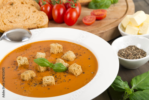 Cream of tomato soup with croutons, black pepper & basil leaves