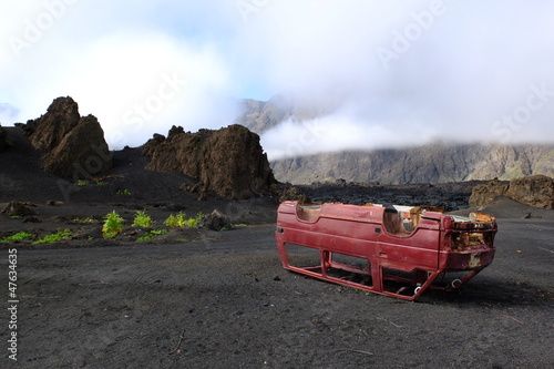 Epave de voiture au milieu d'un champ de lave.