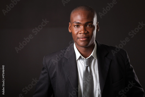 Vászonkép handsome african american businessman over black background