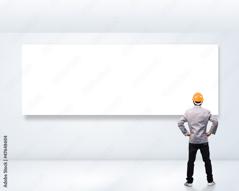engineer person standing near a white blank billboard. engineer person standing near a white blank billboard.