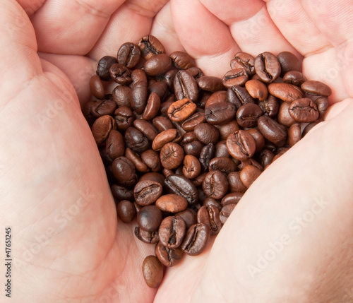 Heart of coffee grains in hands 