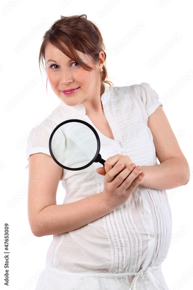 Pregnant woman in white with magnifying glass looks at camera Pregnant woman in white with magnifying glass looks at camera