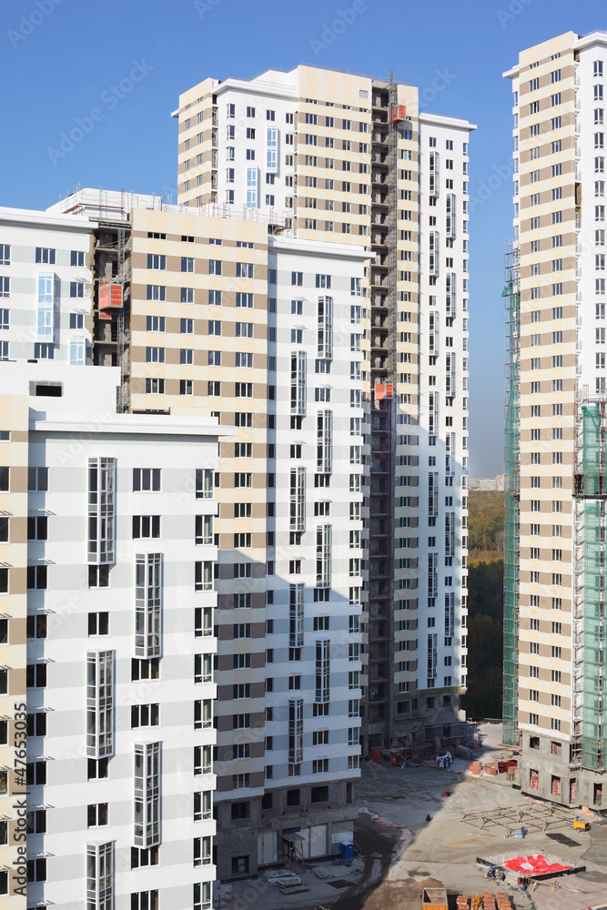 Naklejka premium Parts of high-rise buildings under construction at sunny day.