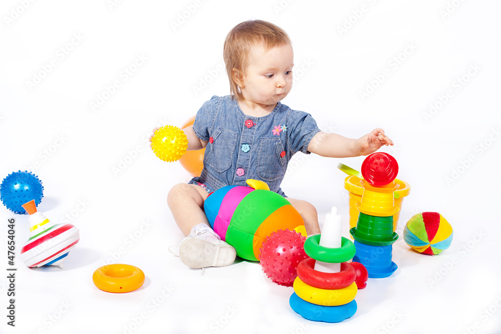 Obraz premium Small child plays with toys. Studio shoot. Isolated