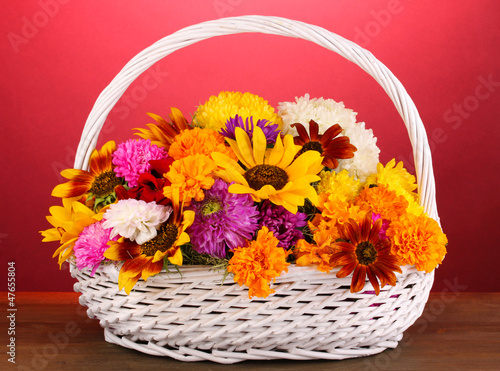 Beautiful bouquet of bright flowers in white basket photo