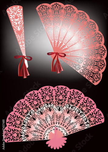 three pink decorated fans on dark background