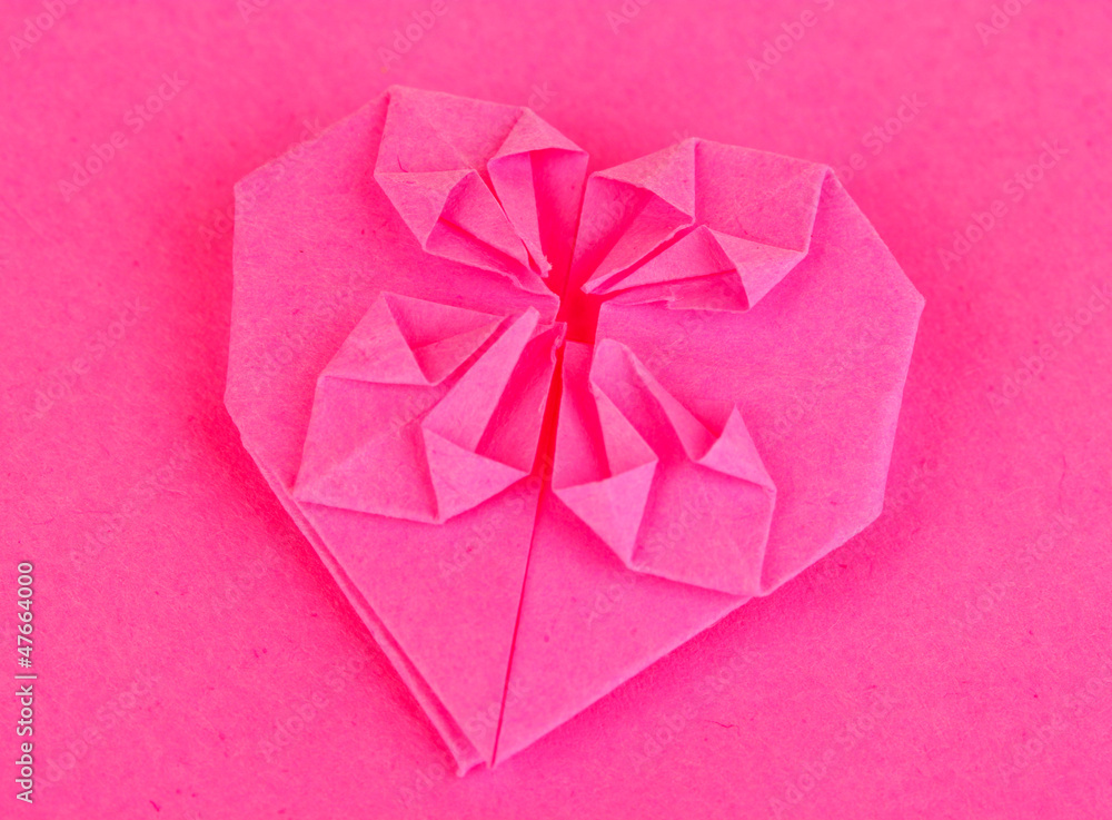 Origami paper heart on pink background Origami paper heart on pink background