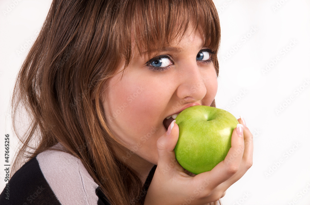 Teenage girl bites an apple. Teenage girl bites an apple.