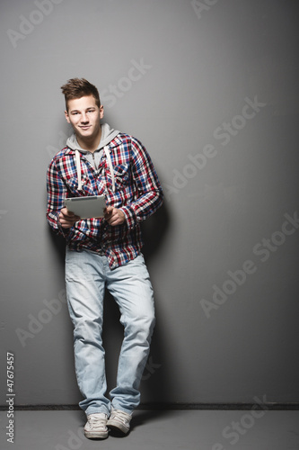 Smiling young urban man with a tablet