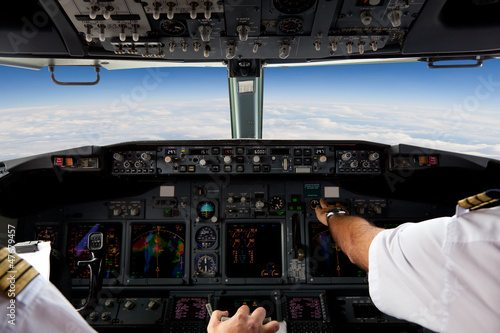 Tableau sur toile Pilotes travaillant dans un avion pendant un vol commercial