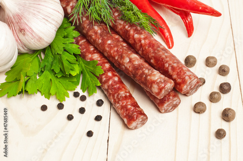 Smoked sausage with spices on a wooden surface